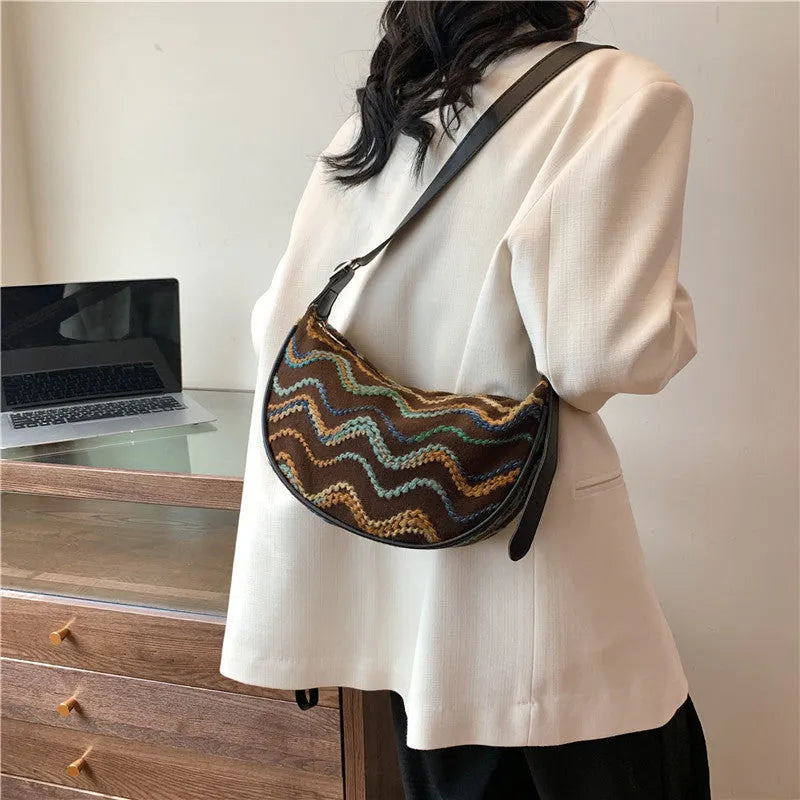 Women's woven straw crossbody bag showing textured surface and internal phone pocket