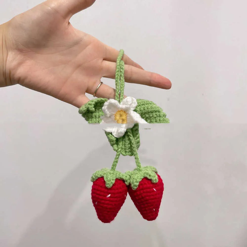 Handmade woven strawberry-shaped car pendant decoration in natural cotton and hemp fibres.