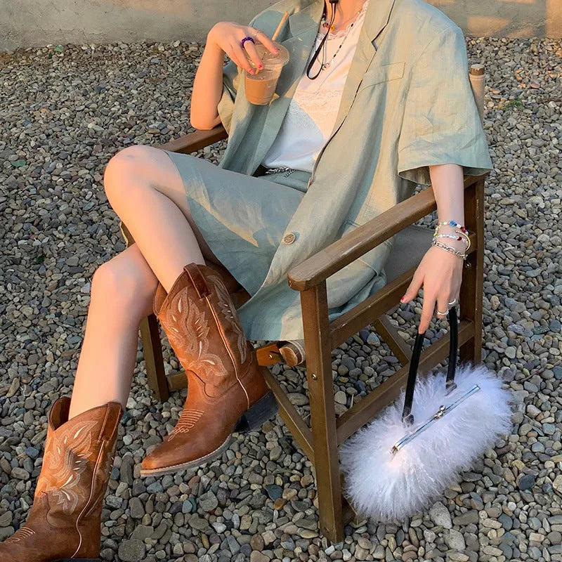 Brown leather women's mid-calf Martin boots with embroidered totem pattern and a waterproof platform sole.