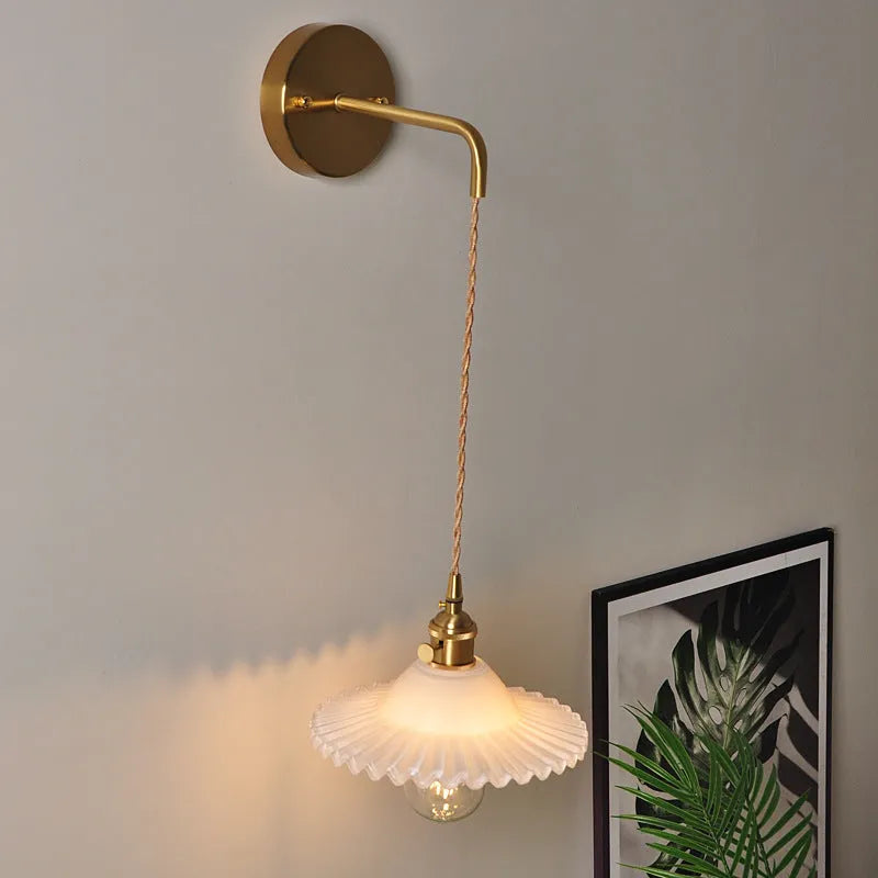 Retro copper lotus wall lamp with glass shade in choice of six colours on a wall.