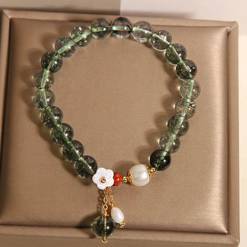 Green phantom quartz crystal bracelet for women with a small white shell flower accent.