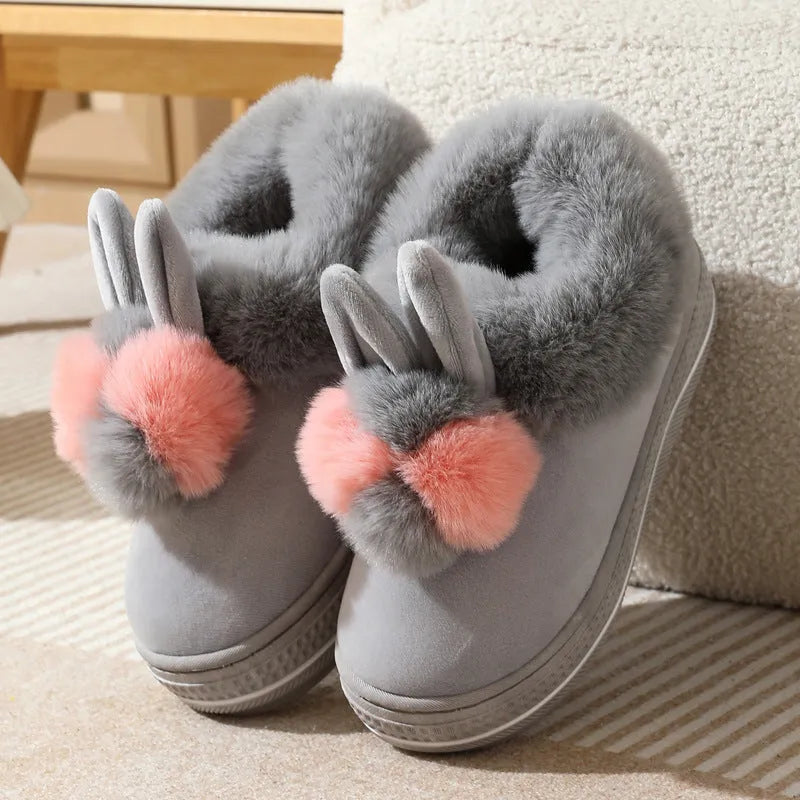 A pair of thick-soled grey plush oversleeve slippers with a textured non-slip sole.