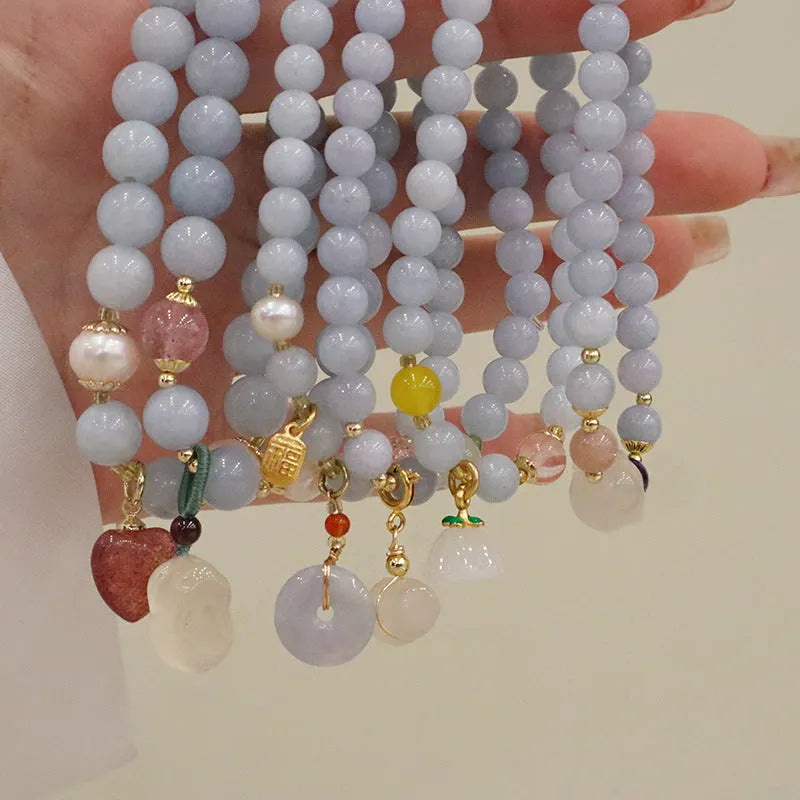 Gold plated women's bracelet with aquamarine chalcedony crystal pendant and floral design.