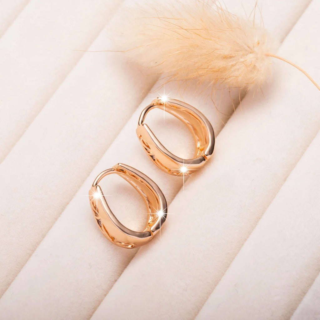 Rose gold copper hollow carved U-shaped women's earrings on a neutral background