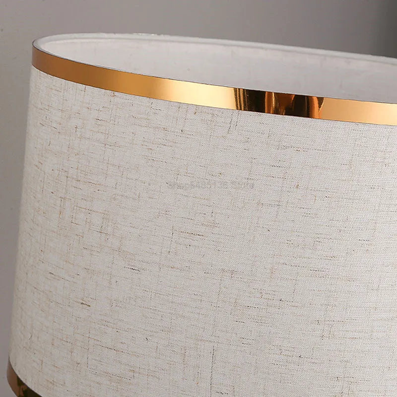Simple iron table lamp with a fabric shade in black, gold, or white colour options.