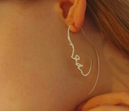 Abstract face contour earrings in gold and silver, 75mm x 35mm