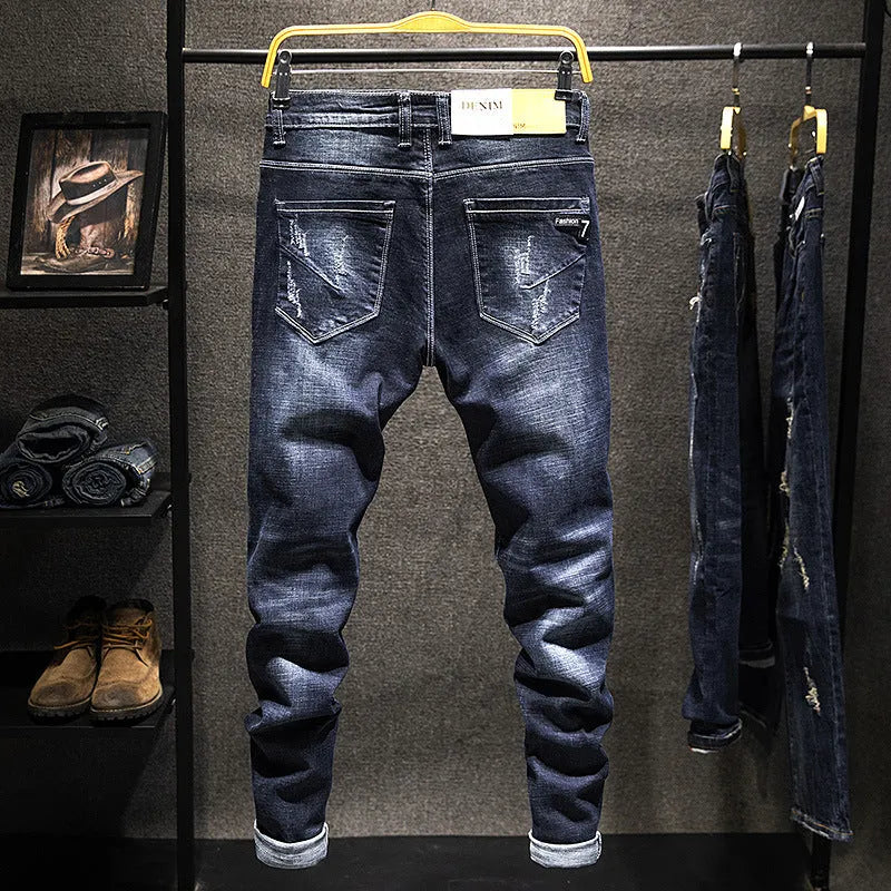 Men's slim-fit dark blue cotton denim jeans with a mid-waist and ankle-length leg.