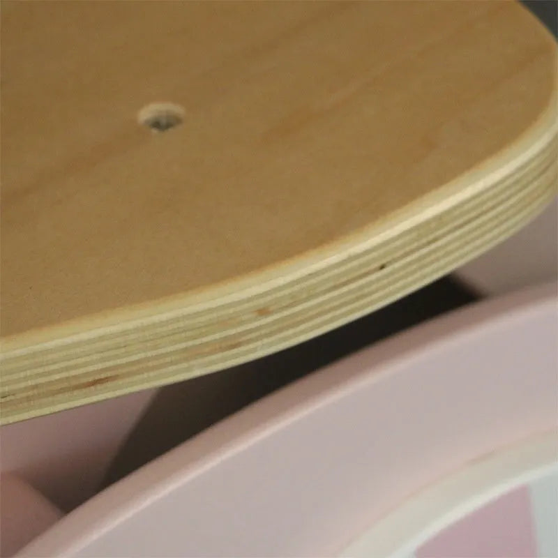 Pink wooden balance scooter for toddlers on a 10-inch wooden deck.