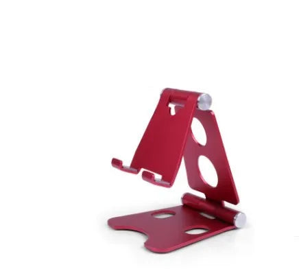 Folding mini mobile phone bracket in black on a wooden desk holding a smartphone
