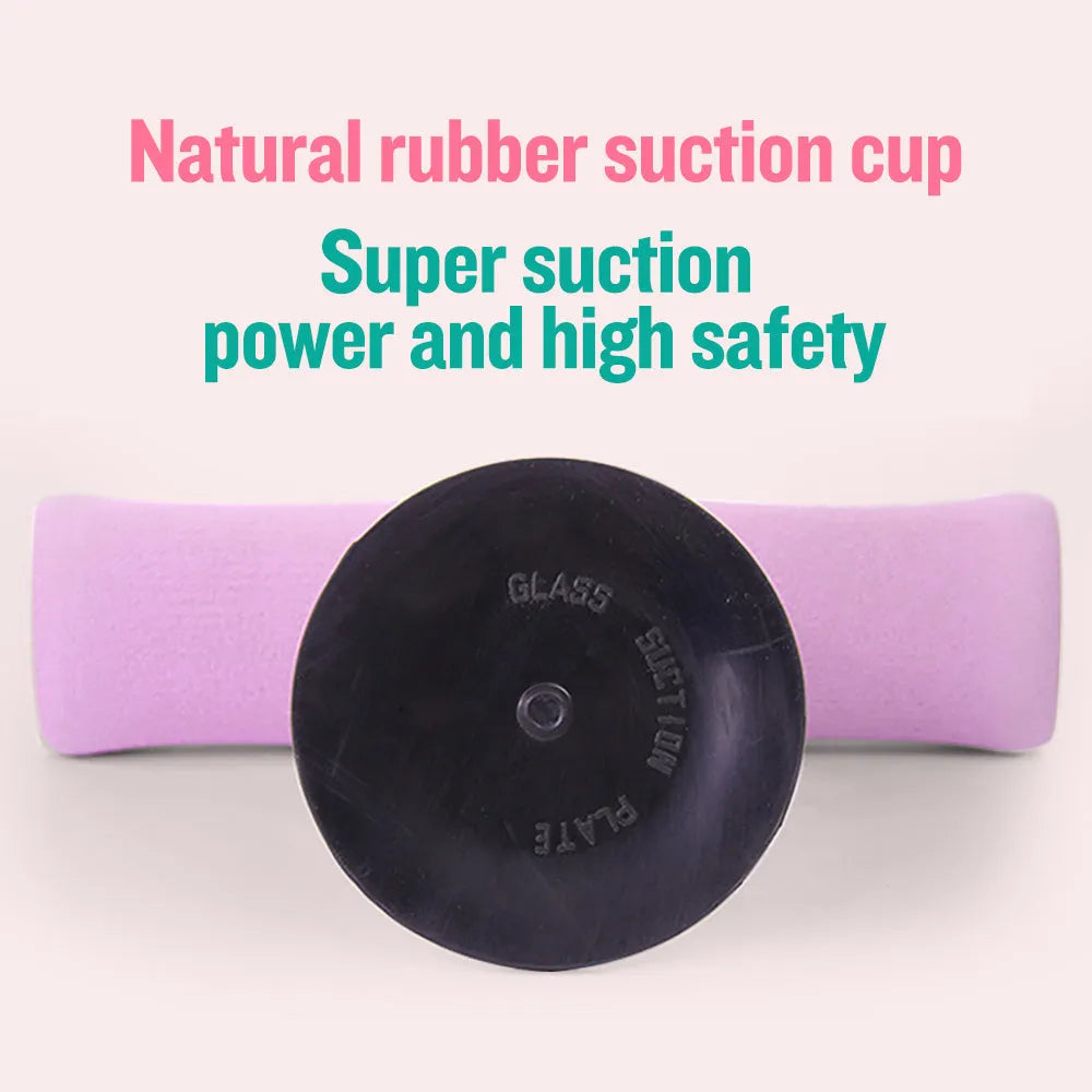 Pink adjustable sit-up bar with foam handles and suction base on a smooth floor for home fitness
