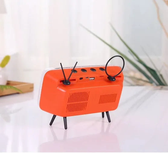 Retro TV mini portable Bluetooth speaker in blue with circular grille and compact 18x8x2.5cm size on a wooden desk