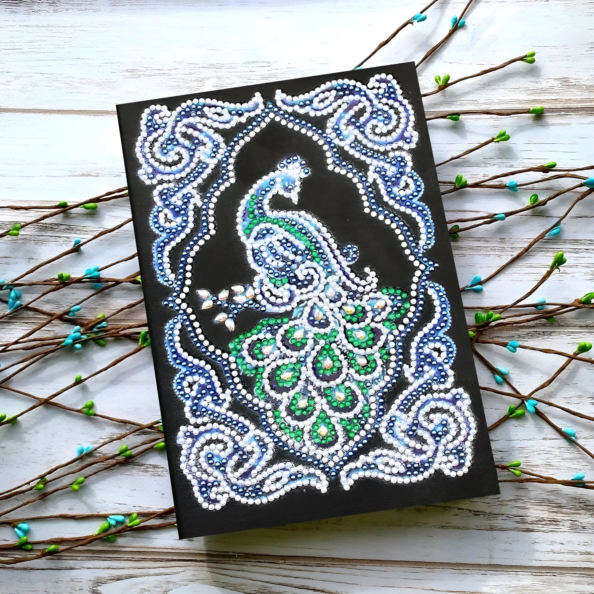 Black A5 diamond painting notebook with peacock design using shaped and bright drills.