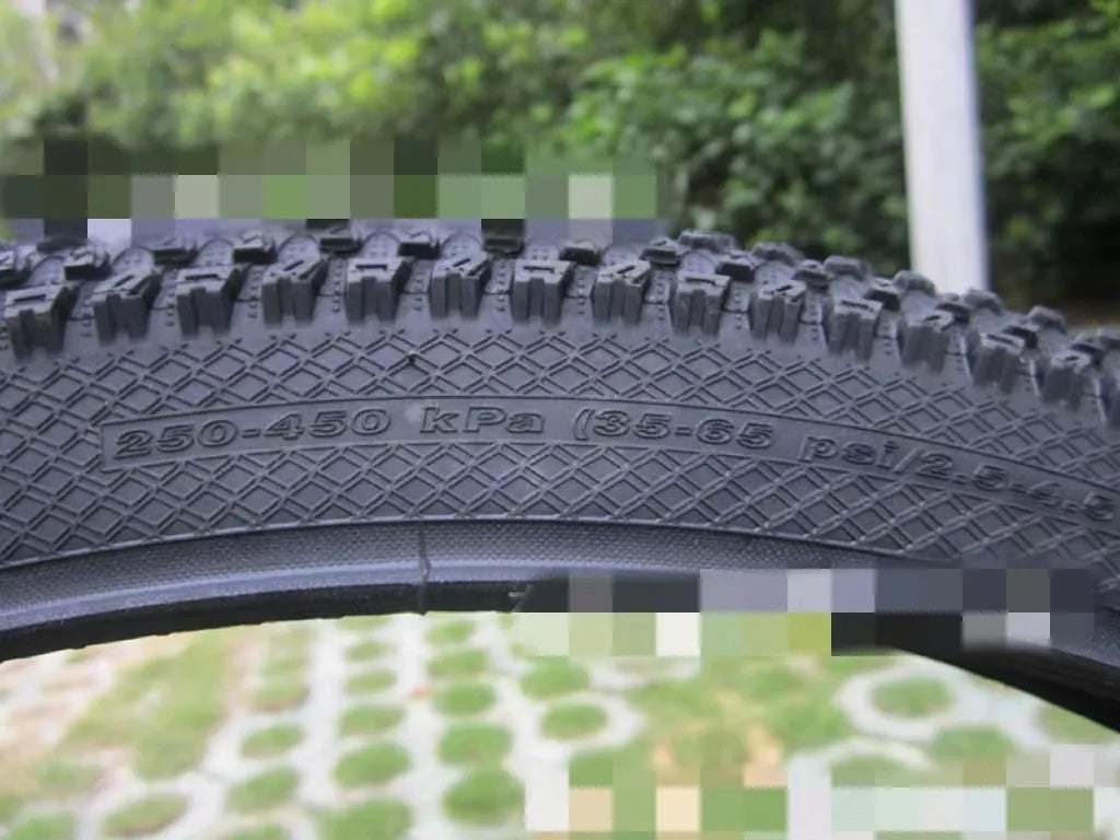 Ultralight puncture-proof mountain bike tyre in multiple sizes on a grey background.