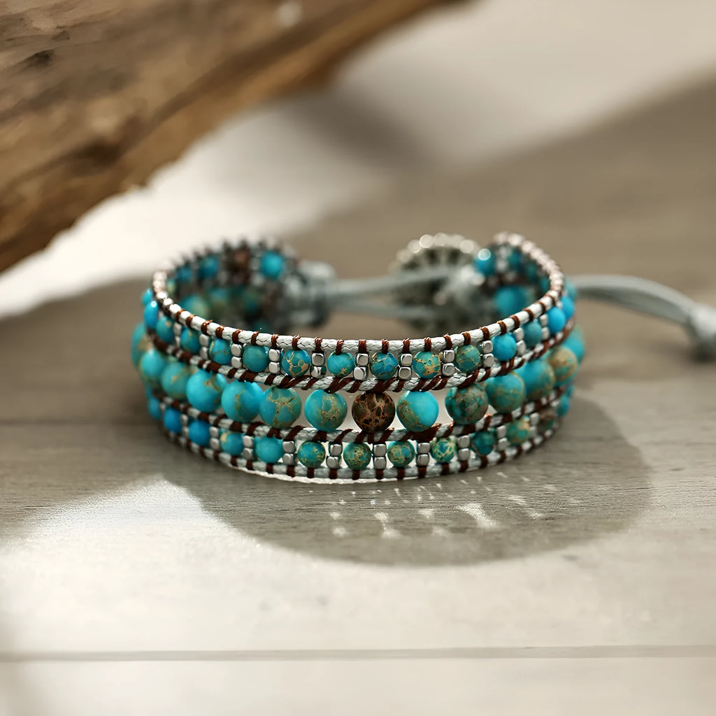 Handmade turquoise geometric inlaid gem bracelet in green with starry sky meteor shower pattern on a white background.
