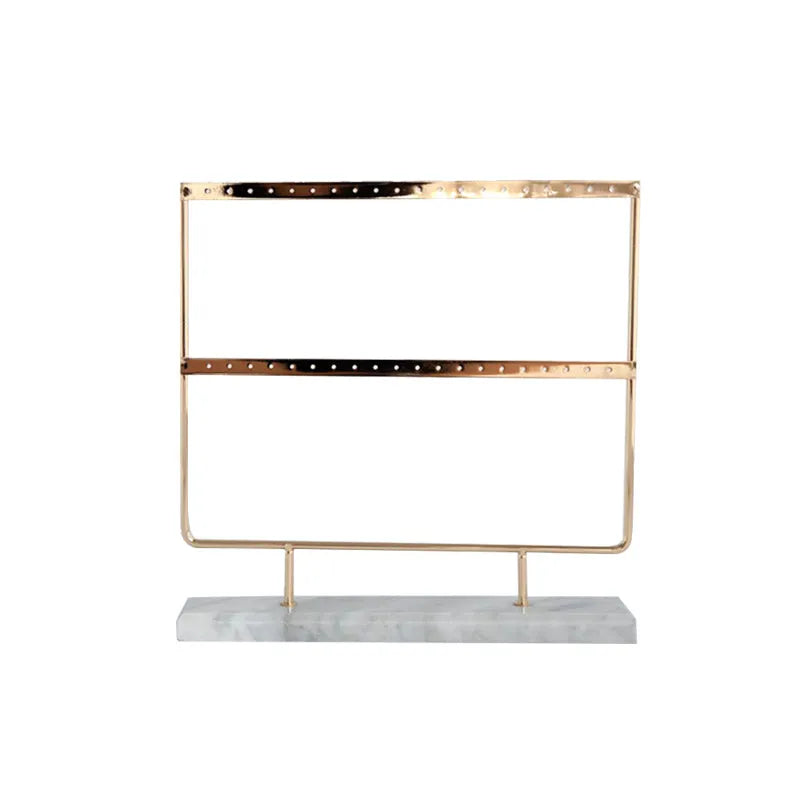 Alloy earring storage rack in green holding stud and drop earrings on a desktop