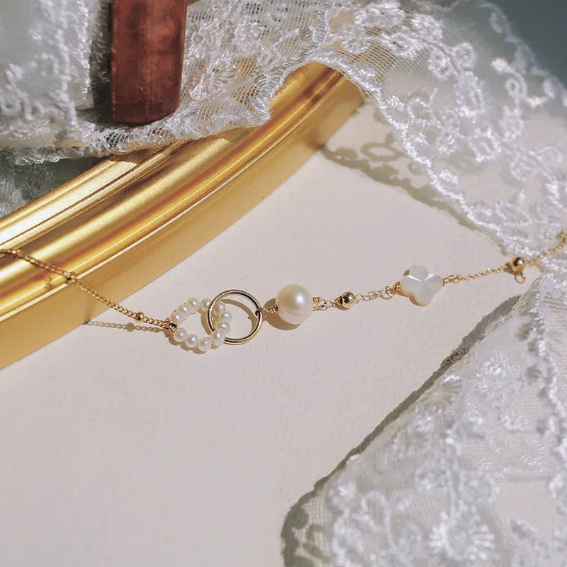 Women's natural pearl bracelet with gold-plated metal setting.