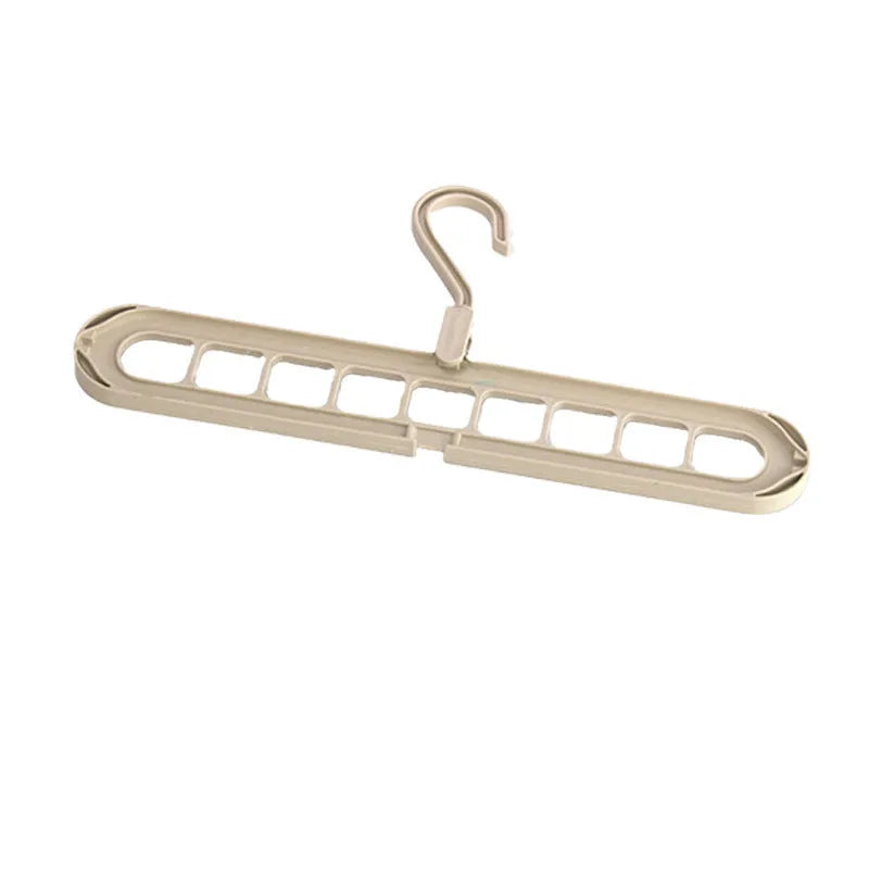 A green nine-hole plastic folding hanger for organising trousers and saving wardrobe space.