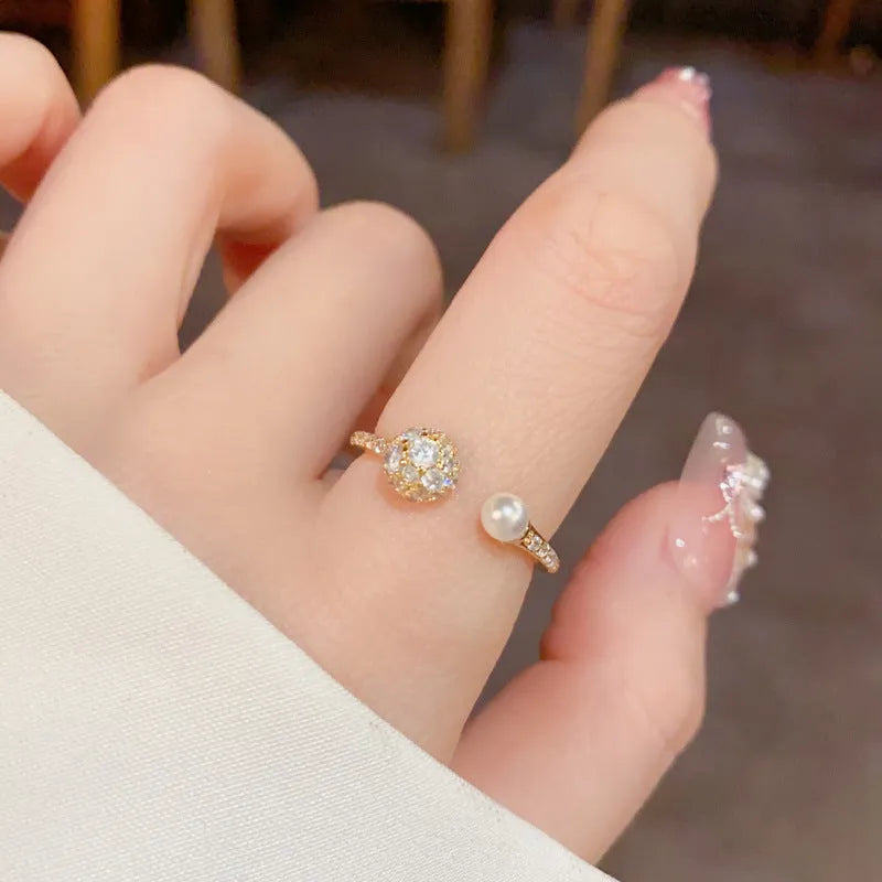 Open-end pearl ring with round zircon stone in gold or silver colour, showing geometric shape and thick real gold plating.