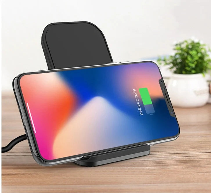 Black wireless charging pad with smartphone positioned vertically on metal surface