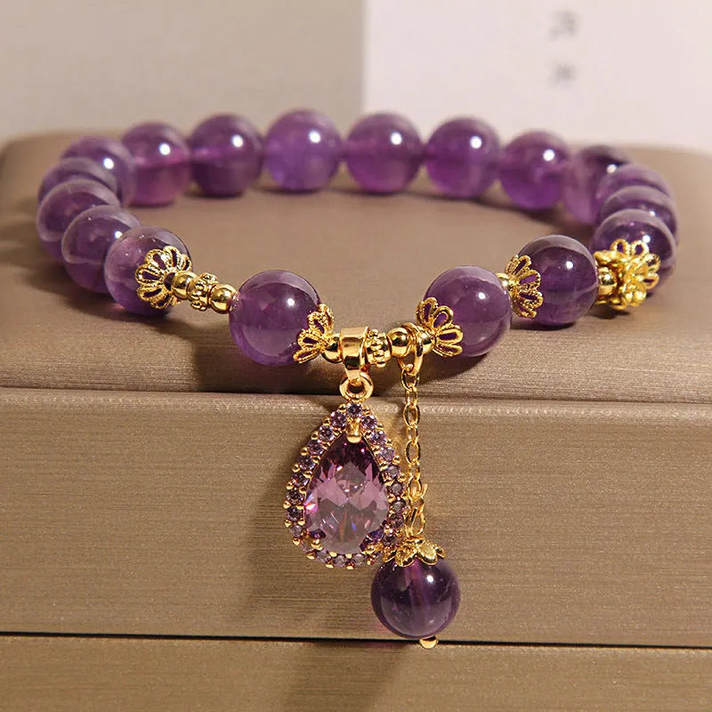 Natural amethyst bracelet with gold-plated inlay and purple droplet pendant on white background