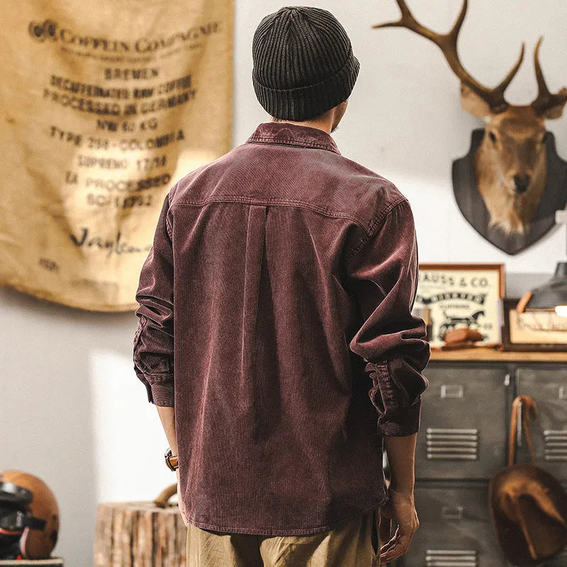 Men's red corduroy loose-fit shirt jacket with long sleeves on a hanger.