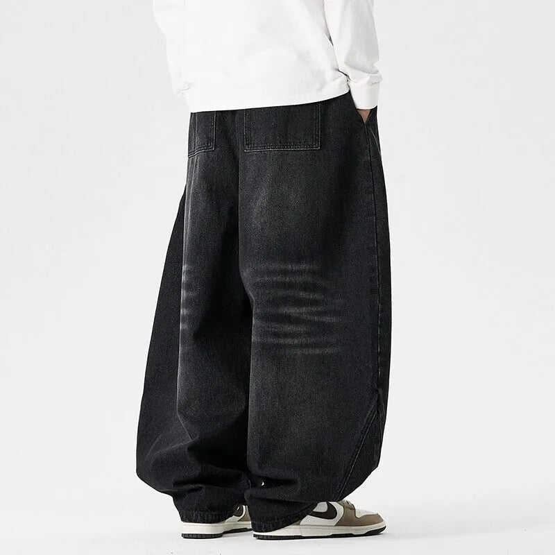 Men's plus-size light blue wide-leg denim jeans with a loose, baggy fit and straight legs on a hanger.