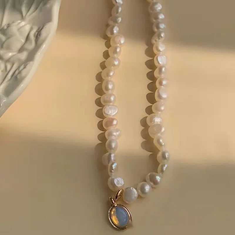 Vintage geometric pearl necklace with an adjustable chain from 21cm to 50cm on a grey background.