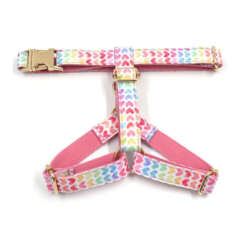 Pink colourful dog harness with gold buckle and heart-shaped stones on chest and back strap.
