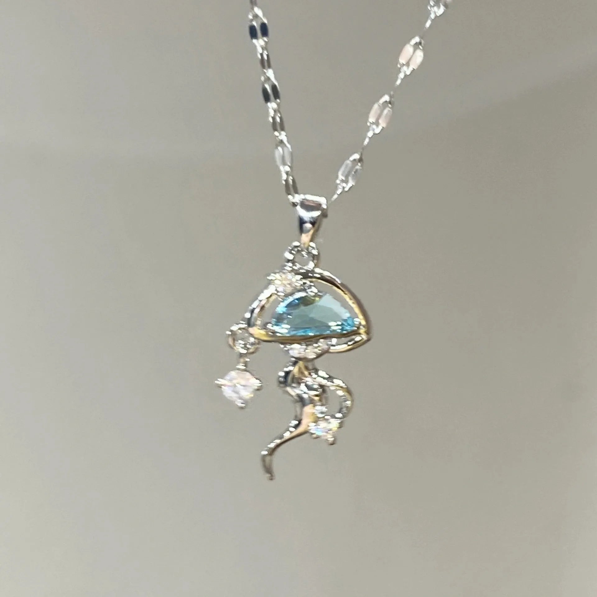 Blue jellyfish pendant on a white gold coloured adjustable sterling silver necklace chain.