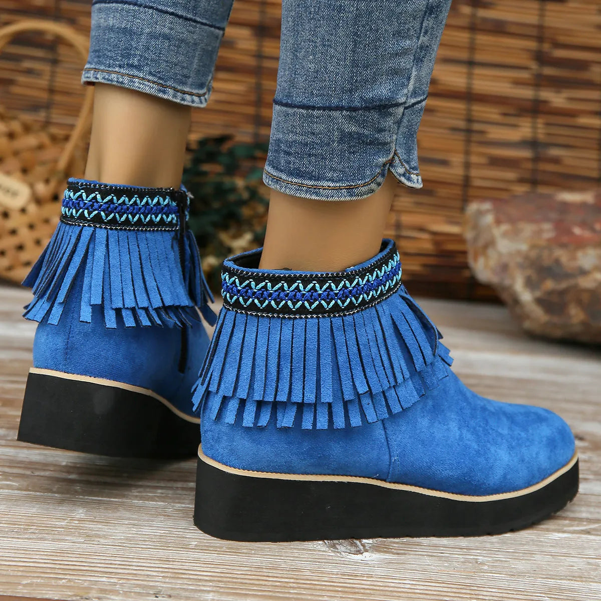 Women's black suede thick sole wedge ankle boots with side zip and tassel detail.