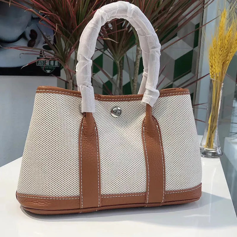Women's canvas crossbody tote bag with leather trim in bucket style showing interior organisation pockets