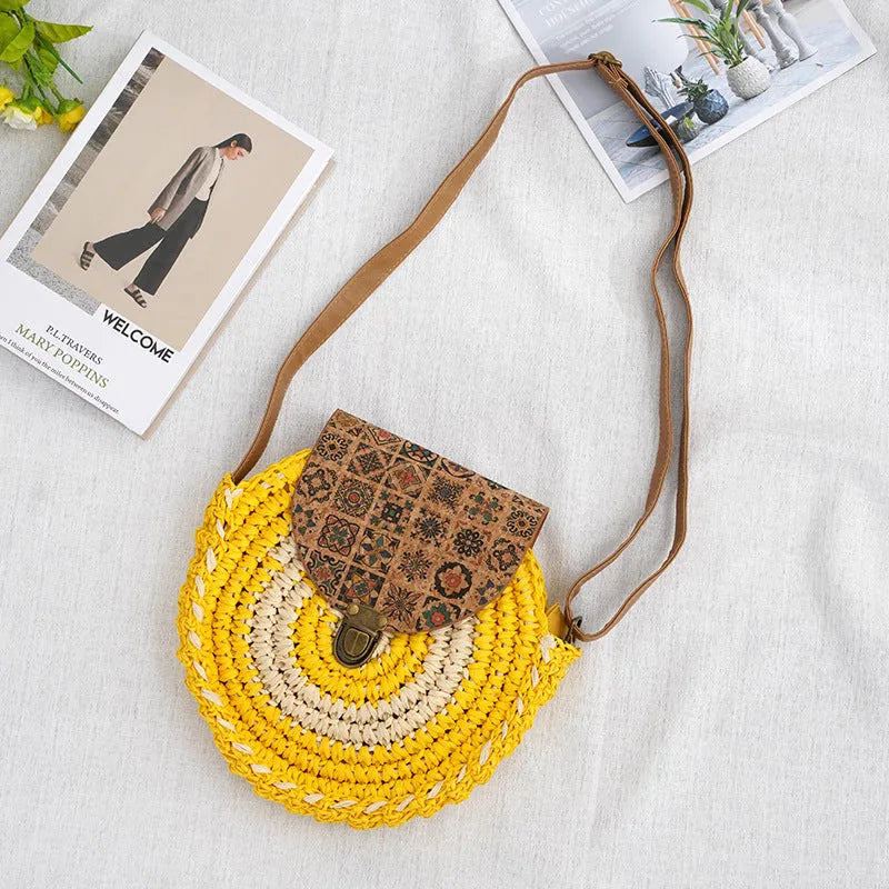Round straw woven crossbody bag in beige, 25cm diameter, with adjustable shoulder strap, displayed on a neutral background