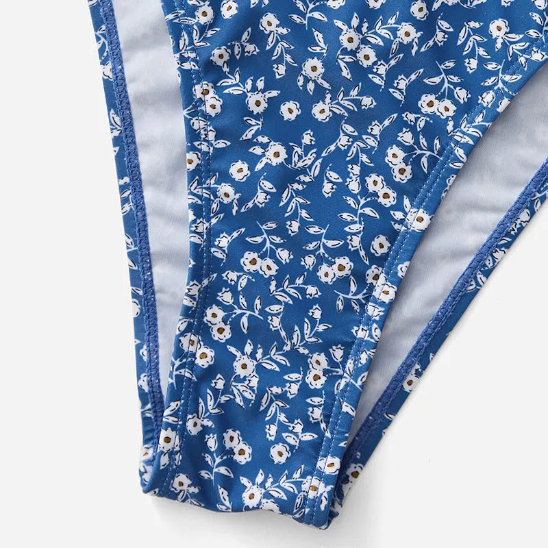 Blue women's swimsuit three-piece set showing separate top and shorts on a neutral background.