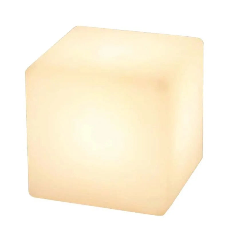 A modern white LED cube light stool sitting outdoors on a patio.