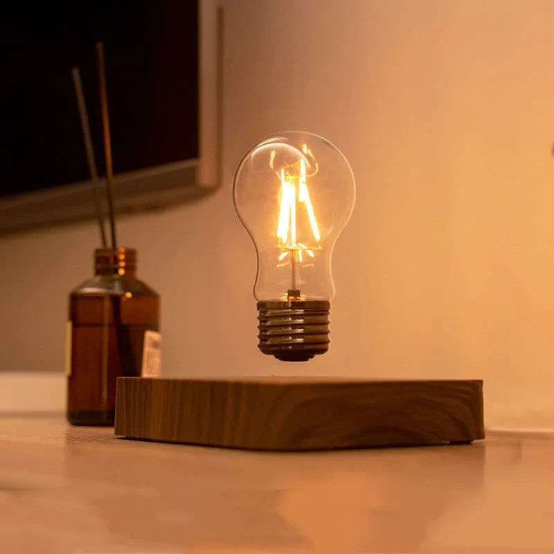 Self-rotating wireless powered maglev bulb with warm yellow light on a compact ABS base