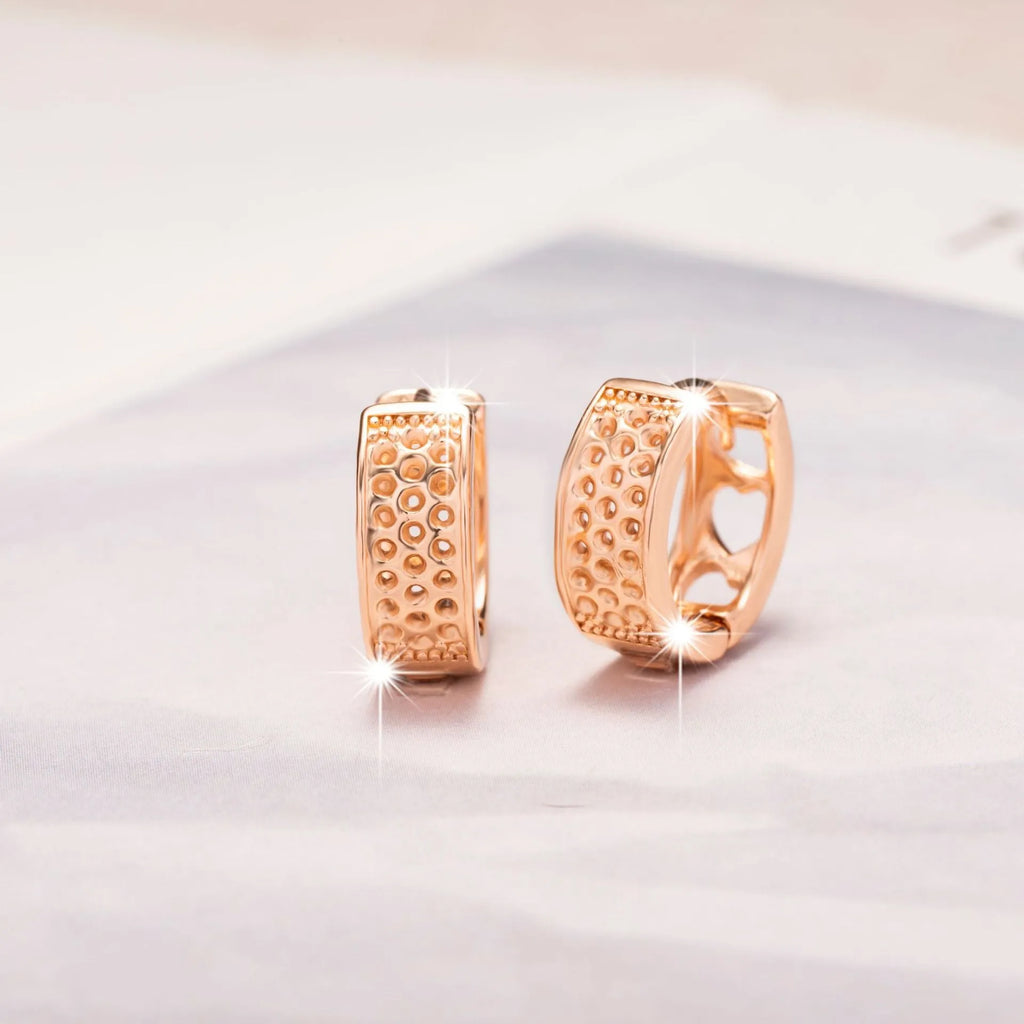 Rose gold women's earrings with a hollowed out heart shape and circular frame.