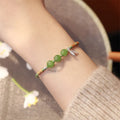 Women's Hetian jade bracelet with handmade woven carrying strap in light green or haze blue chalcedony.