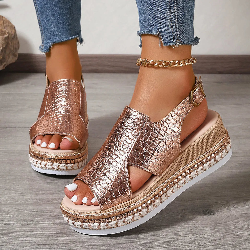 Gold Roman sandals with hollow-out pattern and ankle buckle on model foot