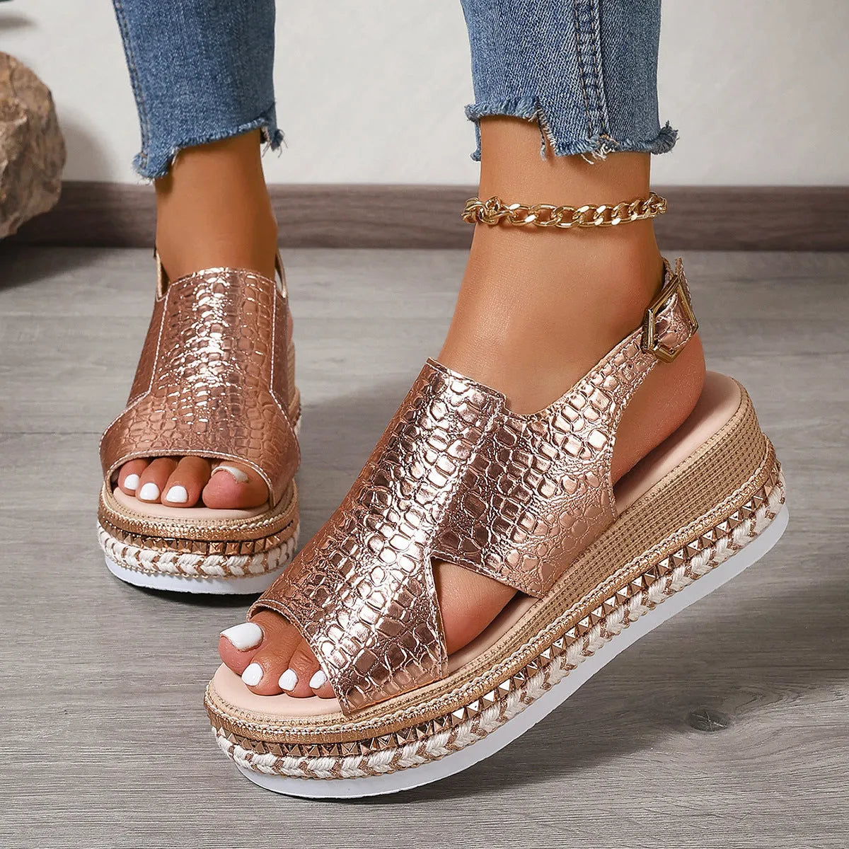 Gold Roman sandals with hollow-out pattern and ankle buckle on model foot
