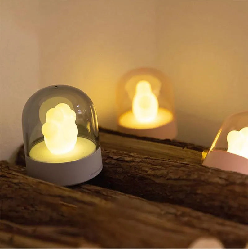Grey cat paw shaped USB rechargeable night light with music box feature on wooden desk