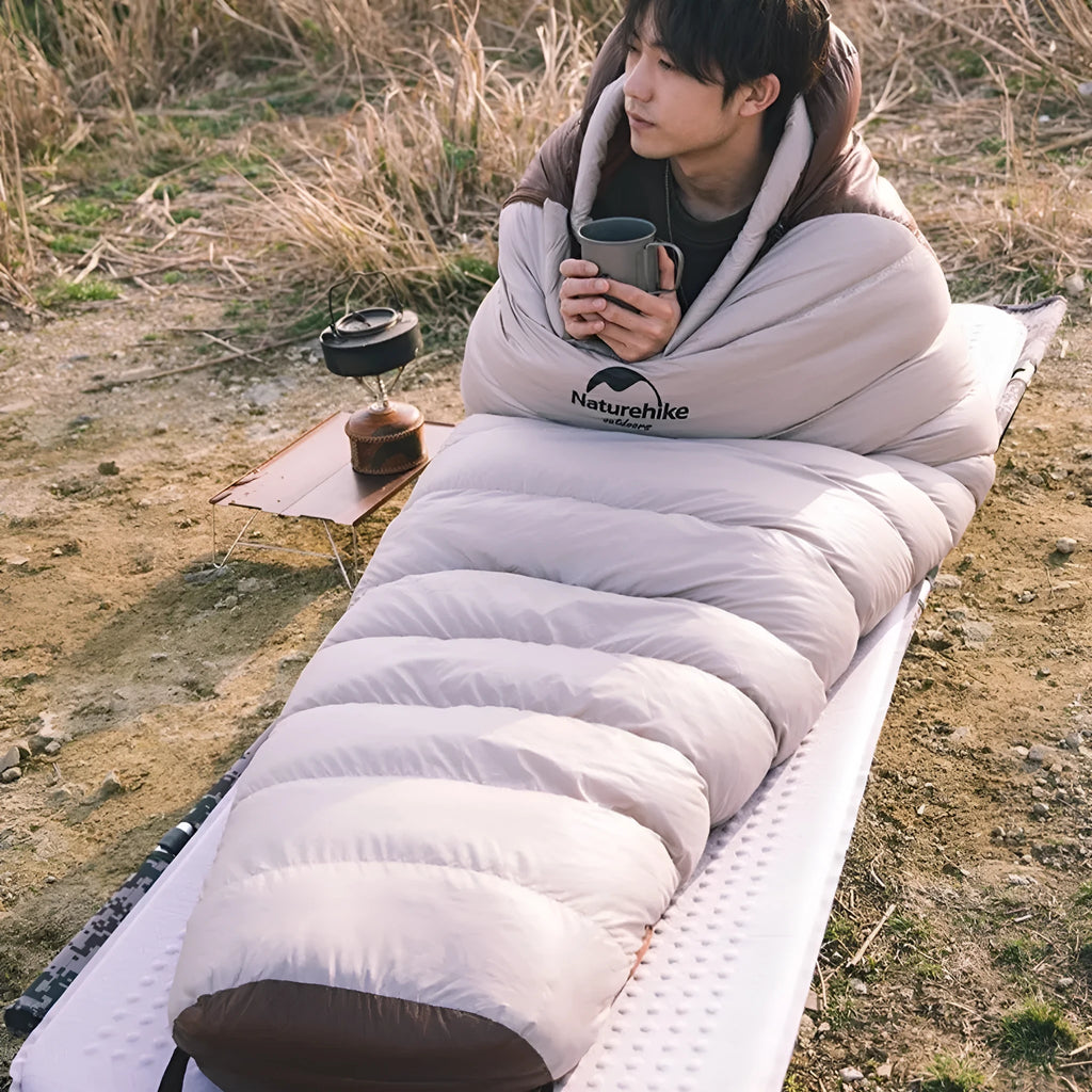 Goose down mummy sleeping bag shown with its compression storage bag.