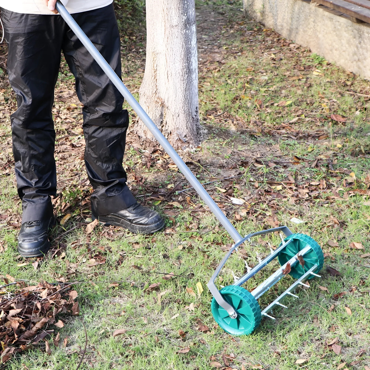 Manual lawn aerator tool with A3 steel construction resting on grass, dimensions 45x24x22cm