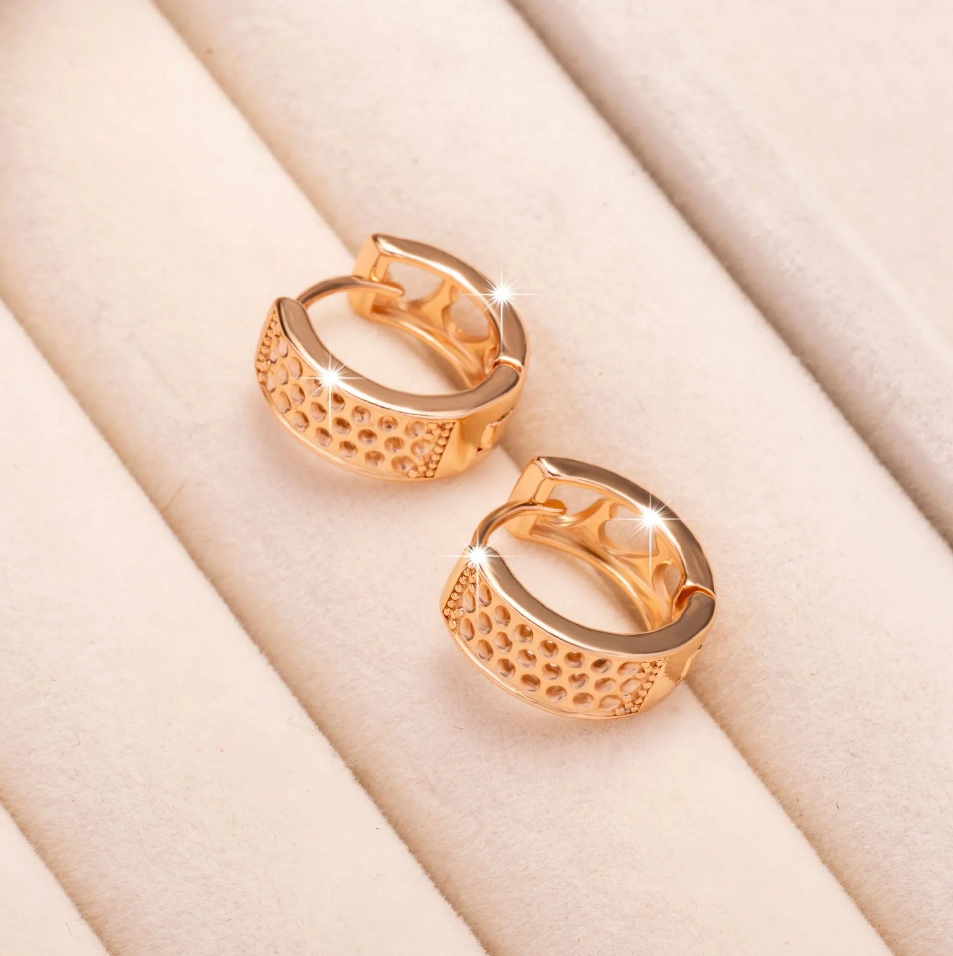 Rose gold women's earrings with a hollowed out heart shape and circular frame.