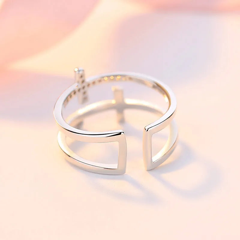 Adjustable double cross geometric ring in copper with sterling silver and zircon stone inlay.