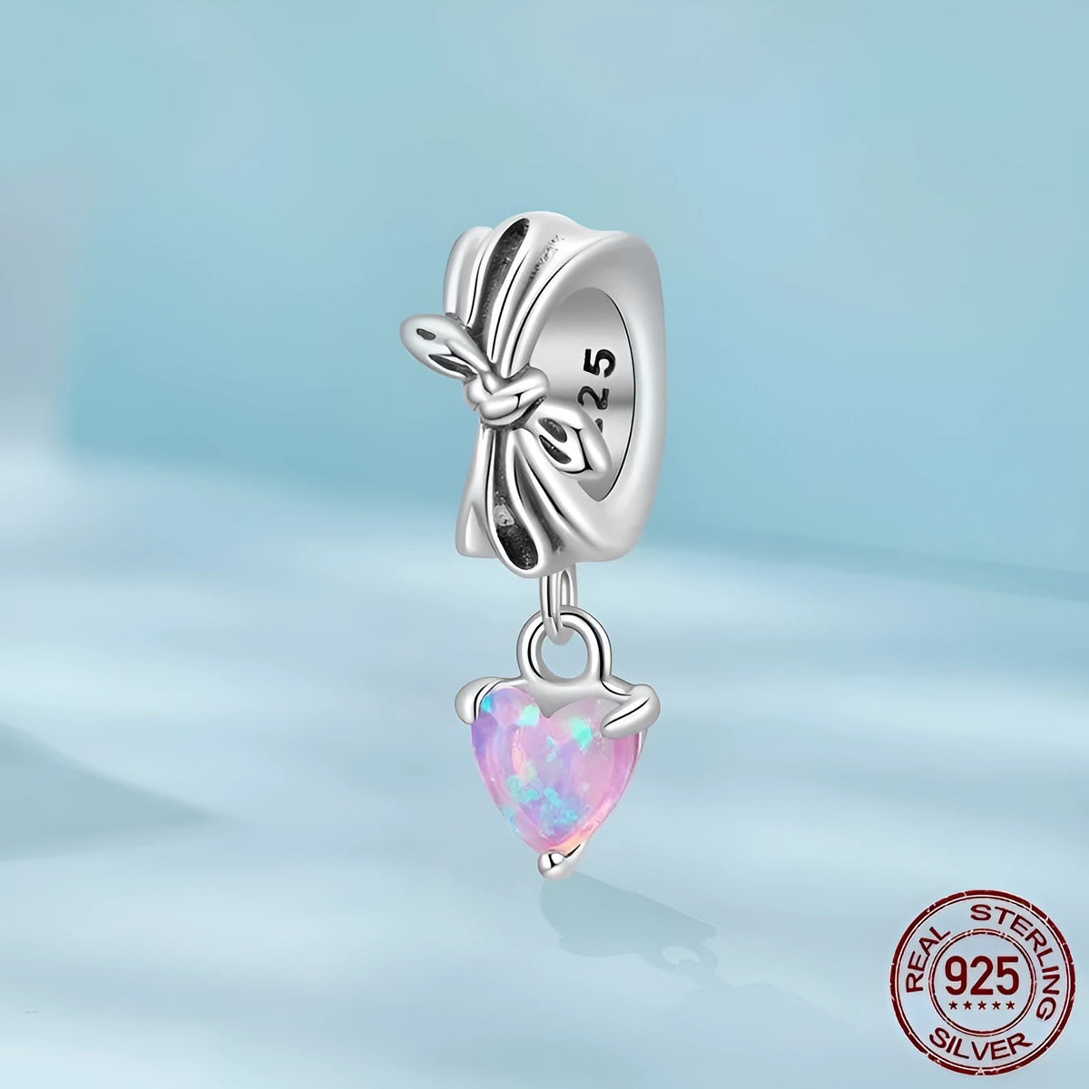 S925 sterling silver pendant with opal bow and loving heart motif, 1.6cm height, on white background