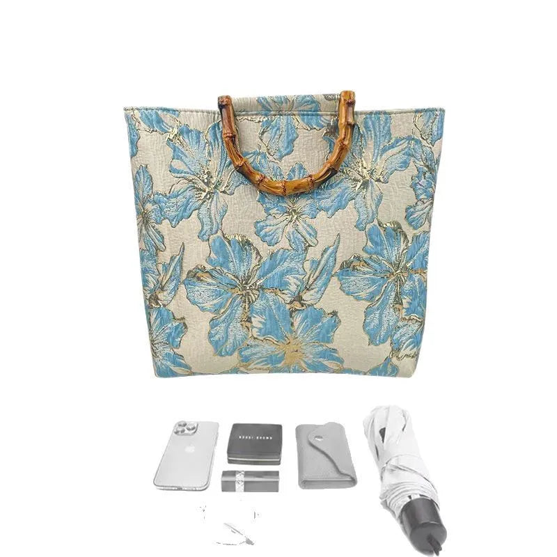 Light blue canvas bag with gold floral pattern showing double shoulder straps and square 30cm shape