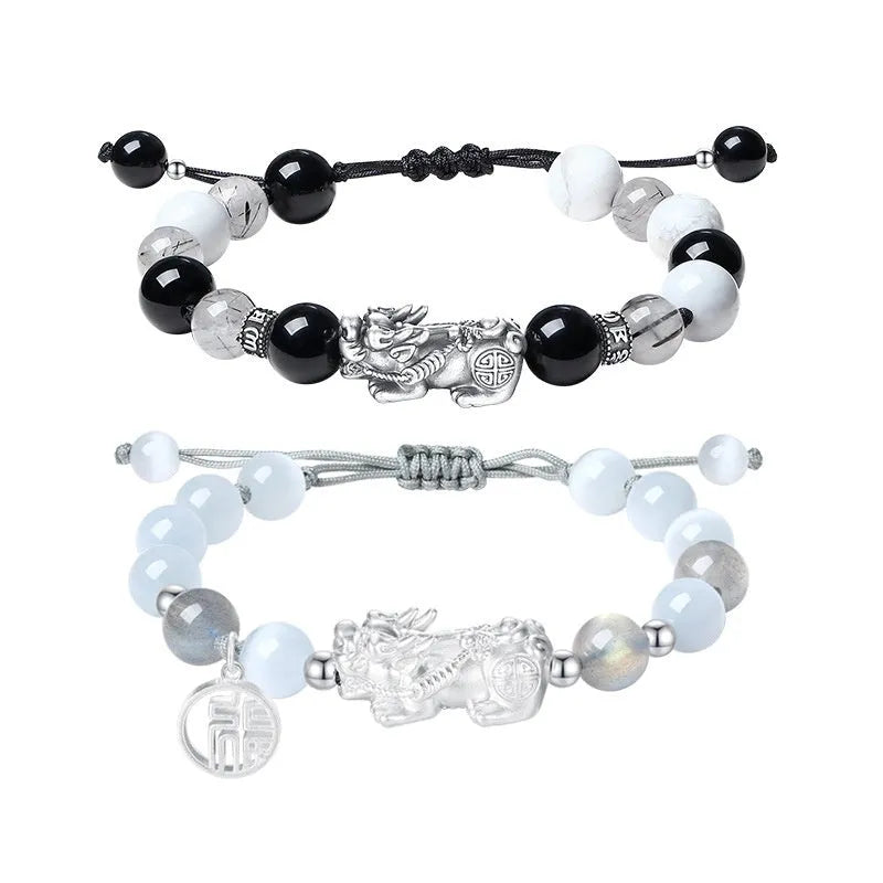 Sterling silver blessing card attached to a hand-woven black and white couple bracelet set with tassel details.