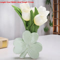Small clover-design ceramic vase in pink, red, light green, or white on a desktop.