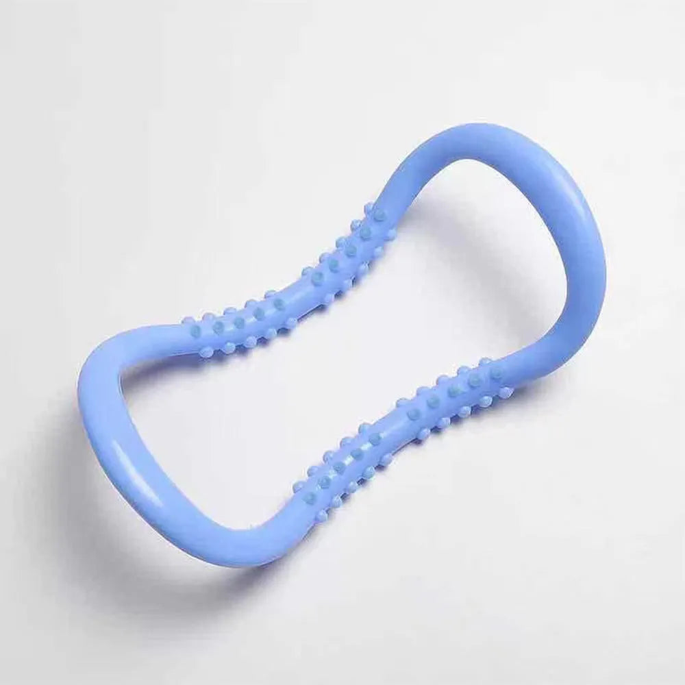 A purple yoga stretching ring made of plastic on a plain background.