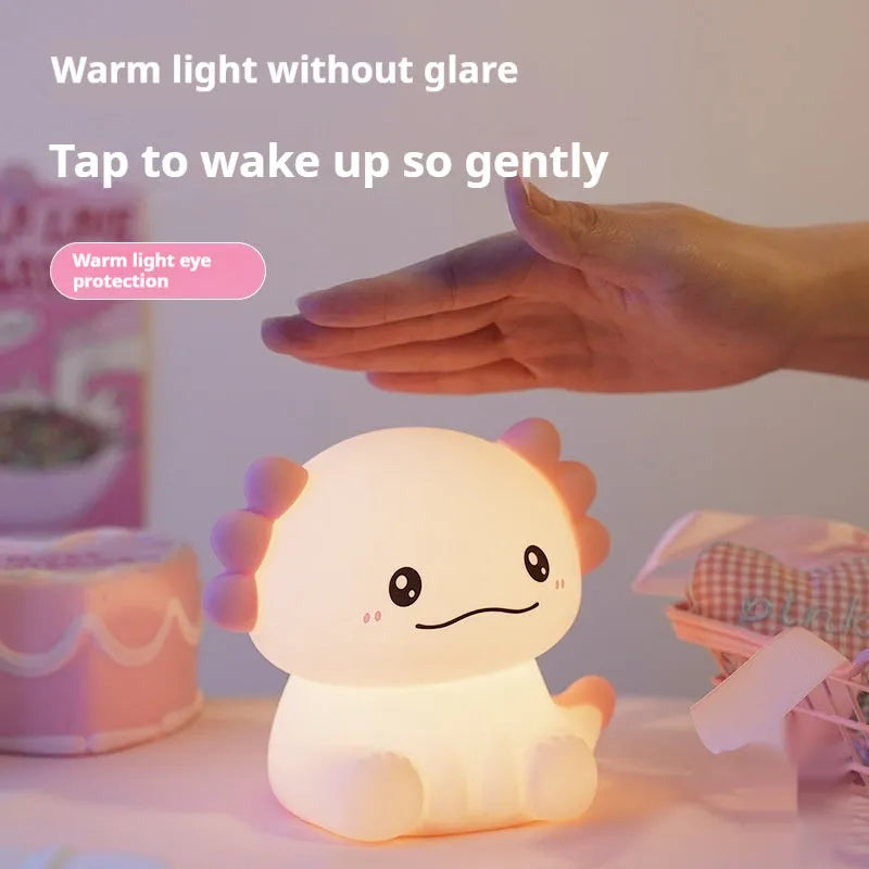 Hexagonal dinosaur-shaped silicone night lamp with warm white glow on a bedside table